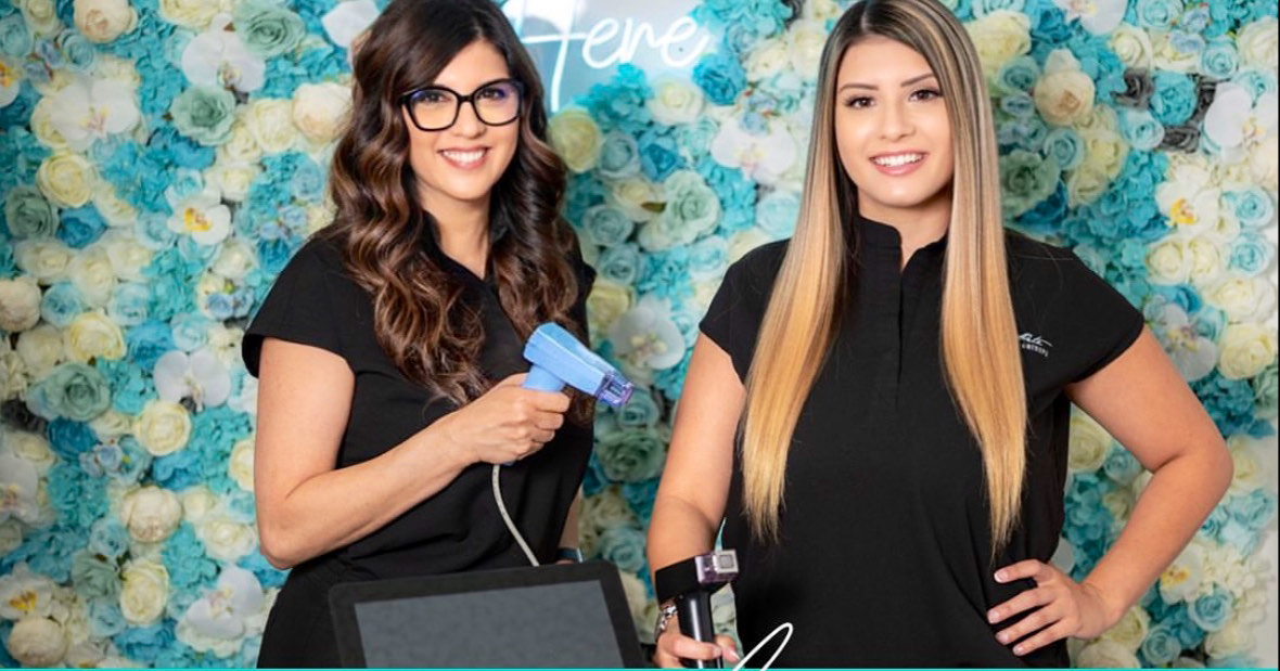 St Pete Wellness Med Spa team beside the spa's signature aqua and white floral wall in downtown St. Petersburg