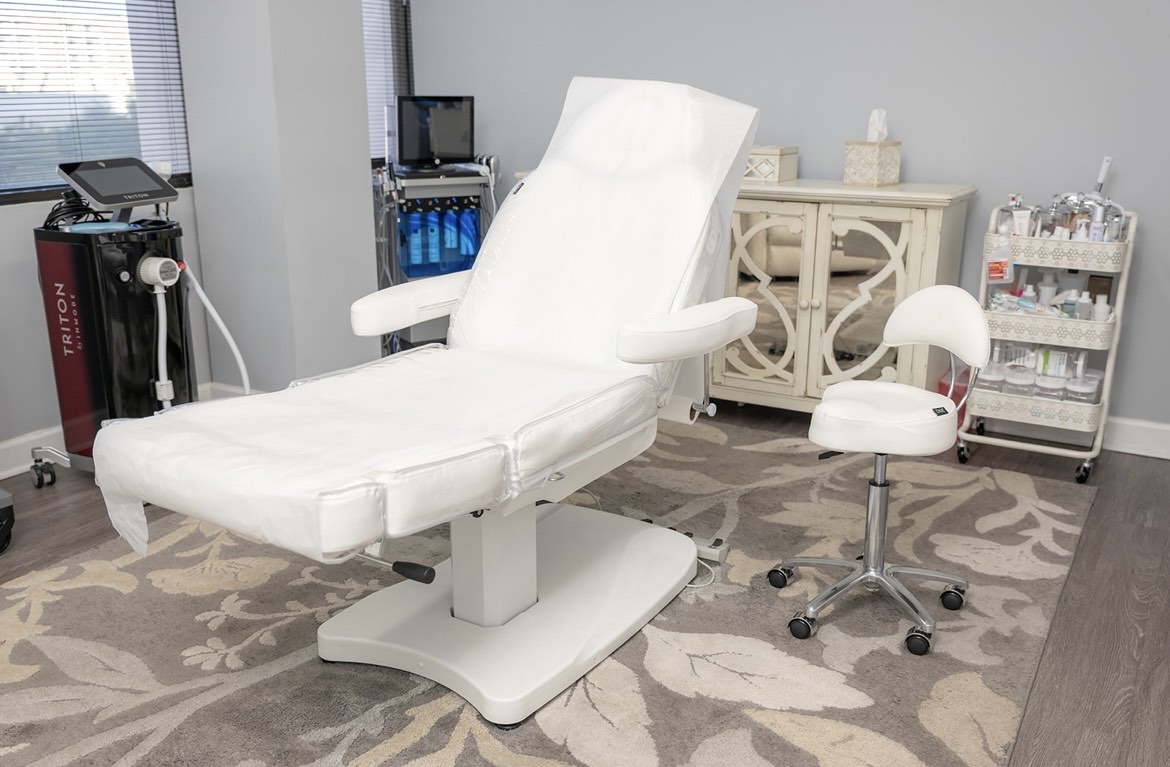 A clean, modern facial and treatment room with medical-grade aesthetic equipment